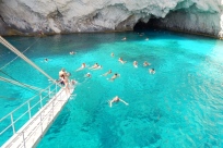 Купание в открытом море возле голубых пещер острова Закинф, Греция
